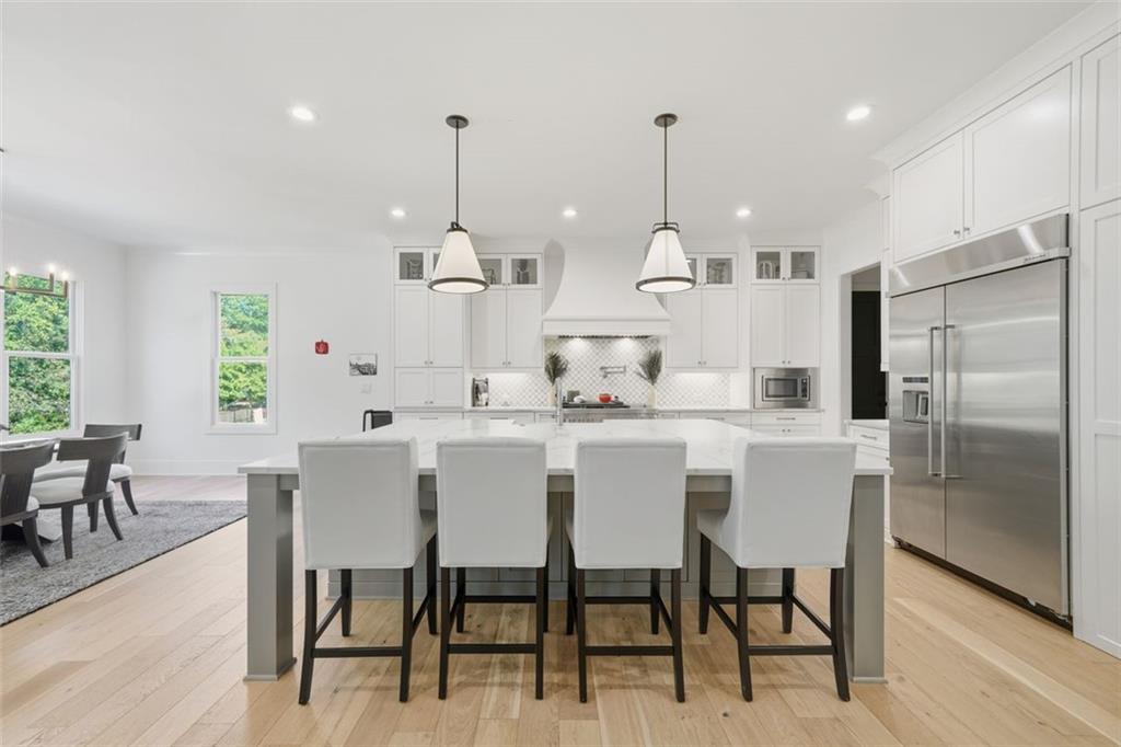 116 Owens Mill Place Canton, GA 30115 - Photo 10 of 65 a kitchen with stainless steel appliances kitchen island granite countertop a dining table chairs and a white refrigerator