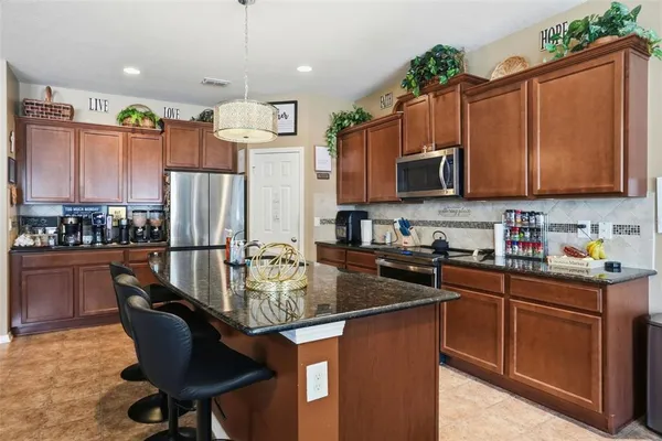 a view of a dining room with furniture one side kitchen view and wooden floor