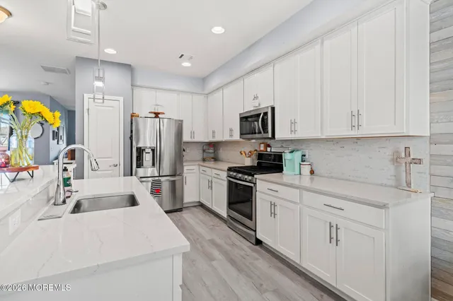 a kitchen with white cabinets and stainless steel appliances