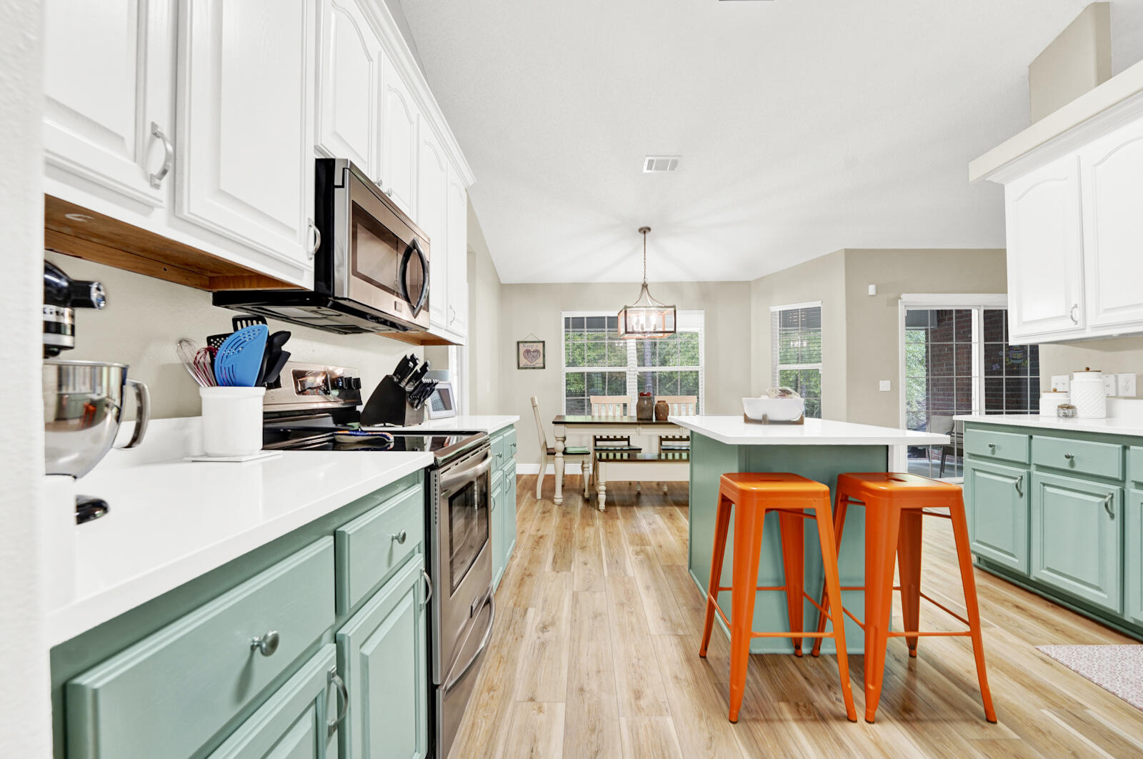304 Greyfox Circle Crestview, FL 32536 - Photo 12 of 49 a kitchen with stainless steel appliances granite countertop sink stove and white cabinets with wooden floor