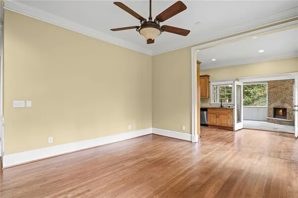 a view of a livingroom with wooden floor and a ceiling fan