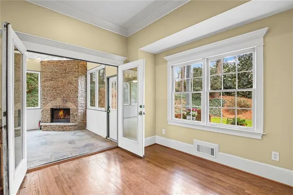 an empty room with wooden floor and windows