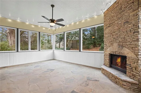 a view of an empty room with windows and a fireplace