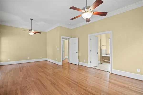 an empty room with wooden floor chandelier fan and closet area