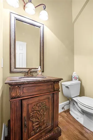 a bathroom with a toilet a sink and mirror