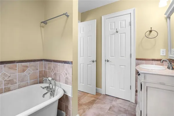 a bathroom with a tub sink and mirror