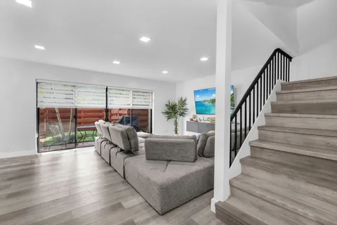 a living room with furniture and a wooden floor