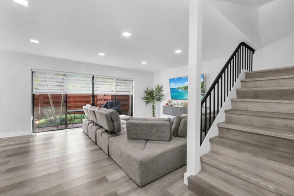 a living room with furniture and a wooden floor