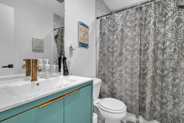 a bathroom with a granite countertop sink and a toilet