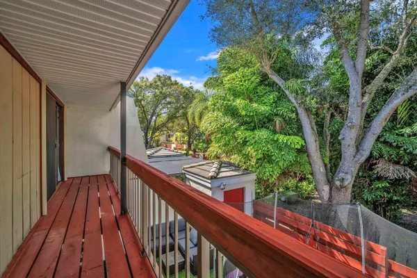 a view of balcony with wooden floor and fence