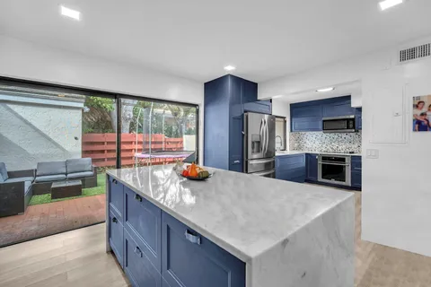 a kitchen with stainless steel appliances granite countertop a sink a stove and a refrigerator