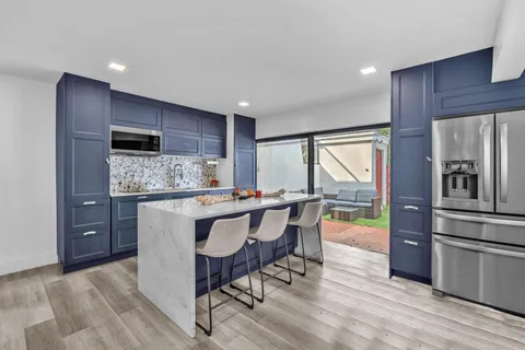 a kitchen with stainless steel appliances granite countertop a refrigerator and a stove top oven