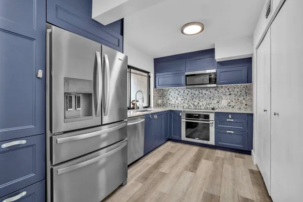 a kitchen with stainless steel appliances kitchen island granite countertop a refrigerator and a stove