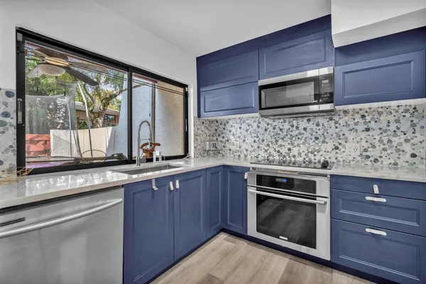 a kitchen with stainless steel appliances wooden cabinets and a stove top oven