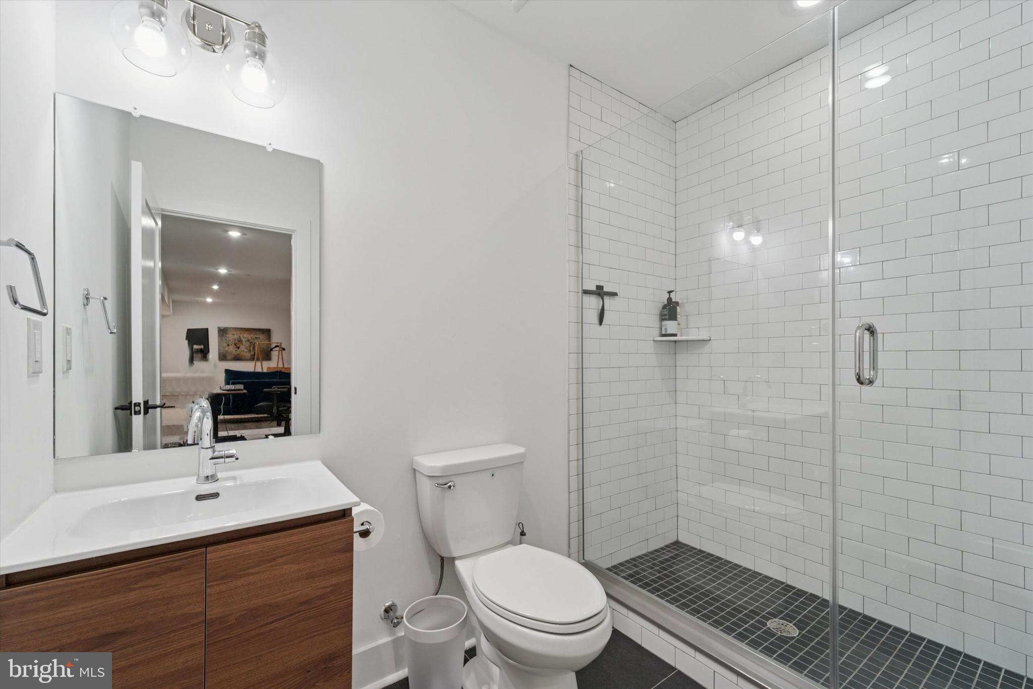 73 East Sharpnack Street Philadelphia, PA 19119 - Photo 16 of 50 a bathroom with a toilet a sink a mirror a shower a vanity and window