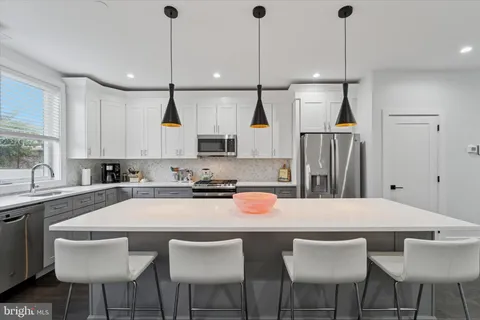 a kitchen with stainless steel appliances a sink a stove and microwave