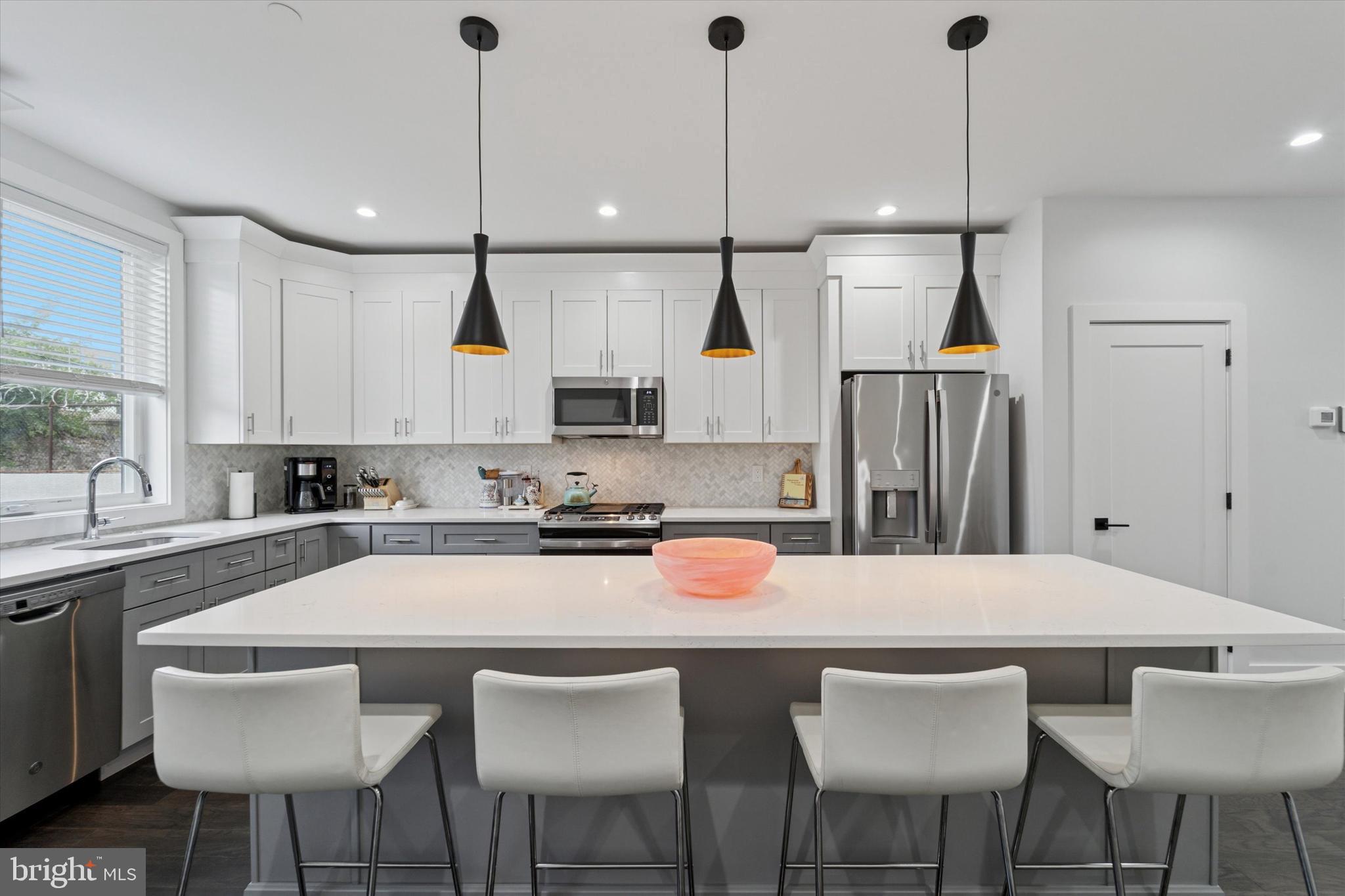 73 East Sharpnack Street Philadelphia, PA 19119 - Photo 8 of 50 a kitchen with stainless steel appliances granite countertop a sink a stove a refrigerator and island with wooden floor
