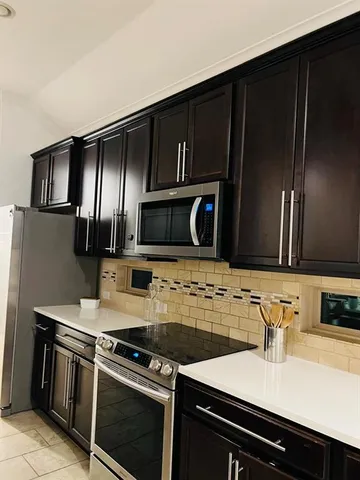 a kitchen with granite countertop stainless steel appliances and wooden cabinets