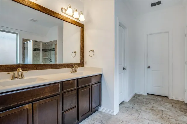 a bathroom with a double vanity sink and a mirror