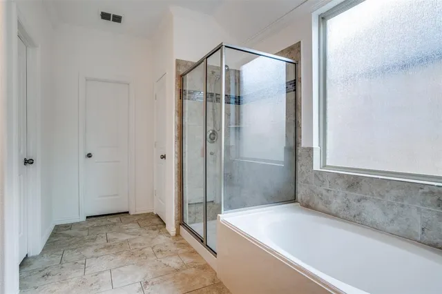 a bathroom with a shower and a bath tub