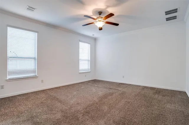 an empty room with a window and a fan