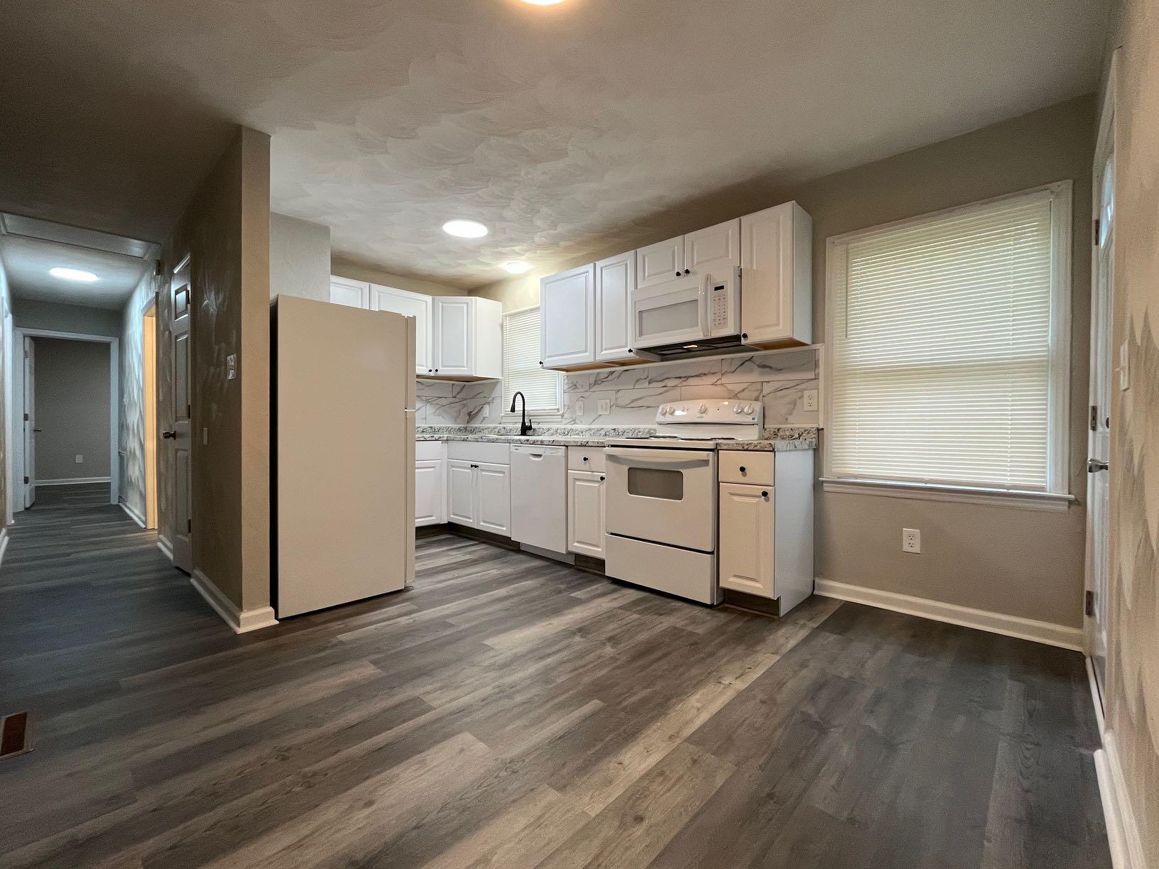 1334 Belleview Avenue Southeast Roanoke, VA 24014 - Photo 11 of 13 a kitchen with stainless steel appliances granite countertop a refrigerator a stove a sink and white cabinets with wooden floor