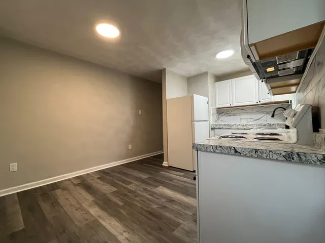 a kitchen with granite countertop a sink and a stove top oven