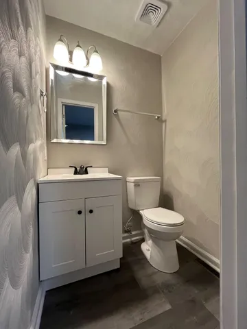 a bathroom with a toilet sink and mirror