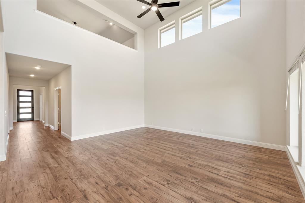 11716 Flathead Court Godley, TX 76044 - Photo 14 of 40 a view of a livingroom with wooden floor and a ceiling fan