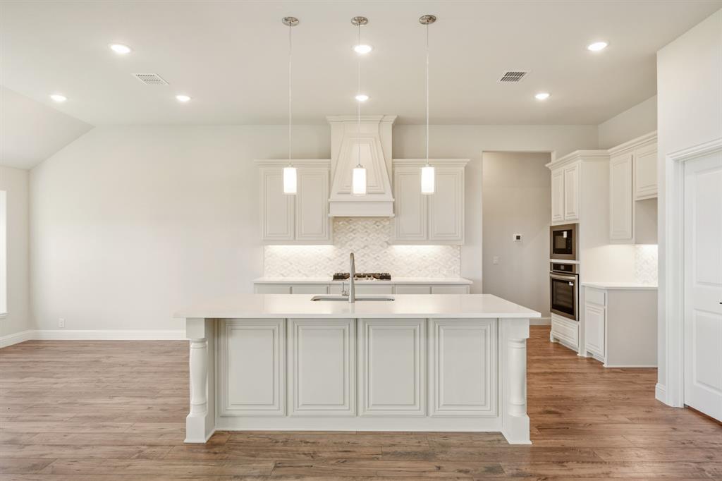 11716 Flathead Court Godley, TX 76044 - Photo 18 of 40 a view of a kitchen with kitchen island a sink stainless steel appliances and cabinets