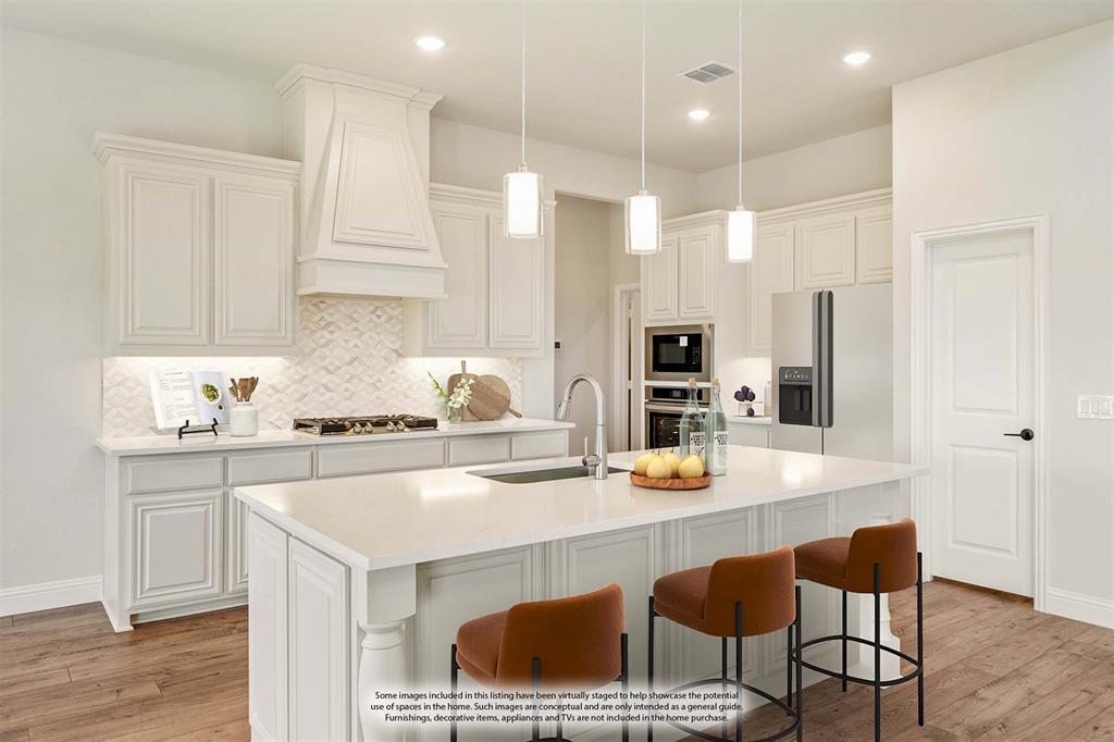 11716 Flathead Court Godley, TX 76044 - Photo 20 of 40 a kitchen with a sink a stove a refrigerator and white cabinets with wooden floor
