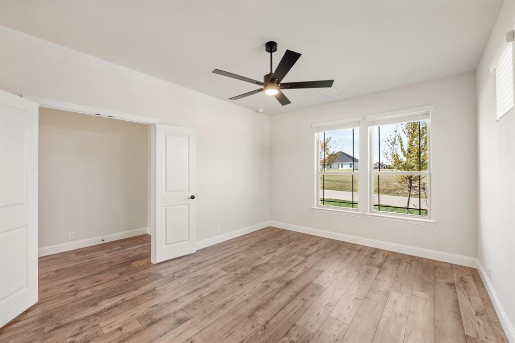 11716 Flathead Court Godley, TX 76044 - Photo 6 of 40 a view of an empty room with a window and wooden floor
