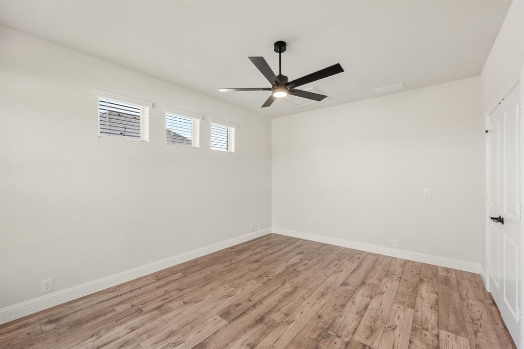 11716 Flathead Court Godley, TX 76044 - Photo 8 of 40 a view of a big room with wooden floor closet and windows