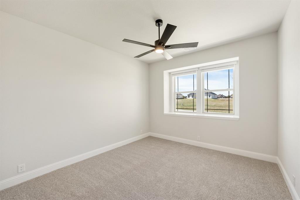 11716 Flathead Court Godley, TX 76044 - Photo 9 of 40 an empty room with a window and a fan