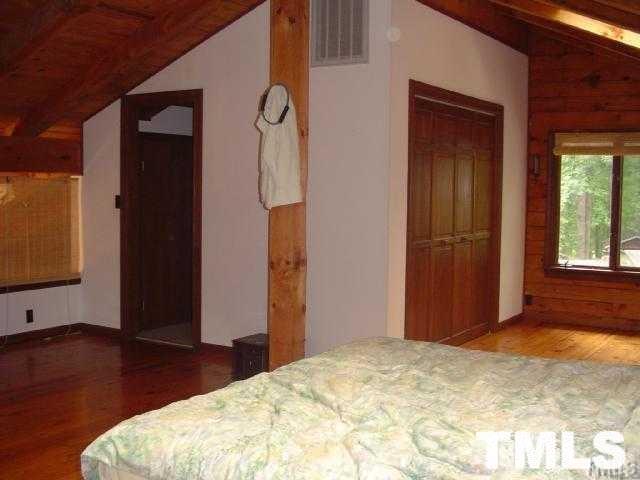 8212 Ridgeback Road Apex, NC 27523 - Photo 3 of 7 a bedroom with a bed and a mirror