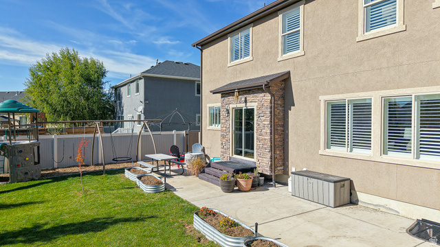 368 East 700 North Springville, UT 84663 - Photo 42 of 55 Rear view of house with a fenced backyard, stucco siding, a patio area, and stone siding