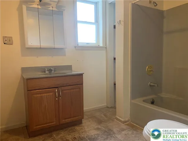 a bathroom with a sink a toilet and bathtub