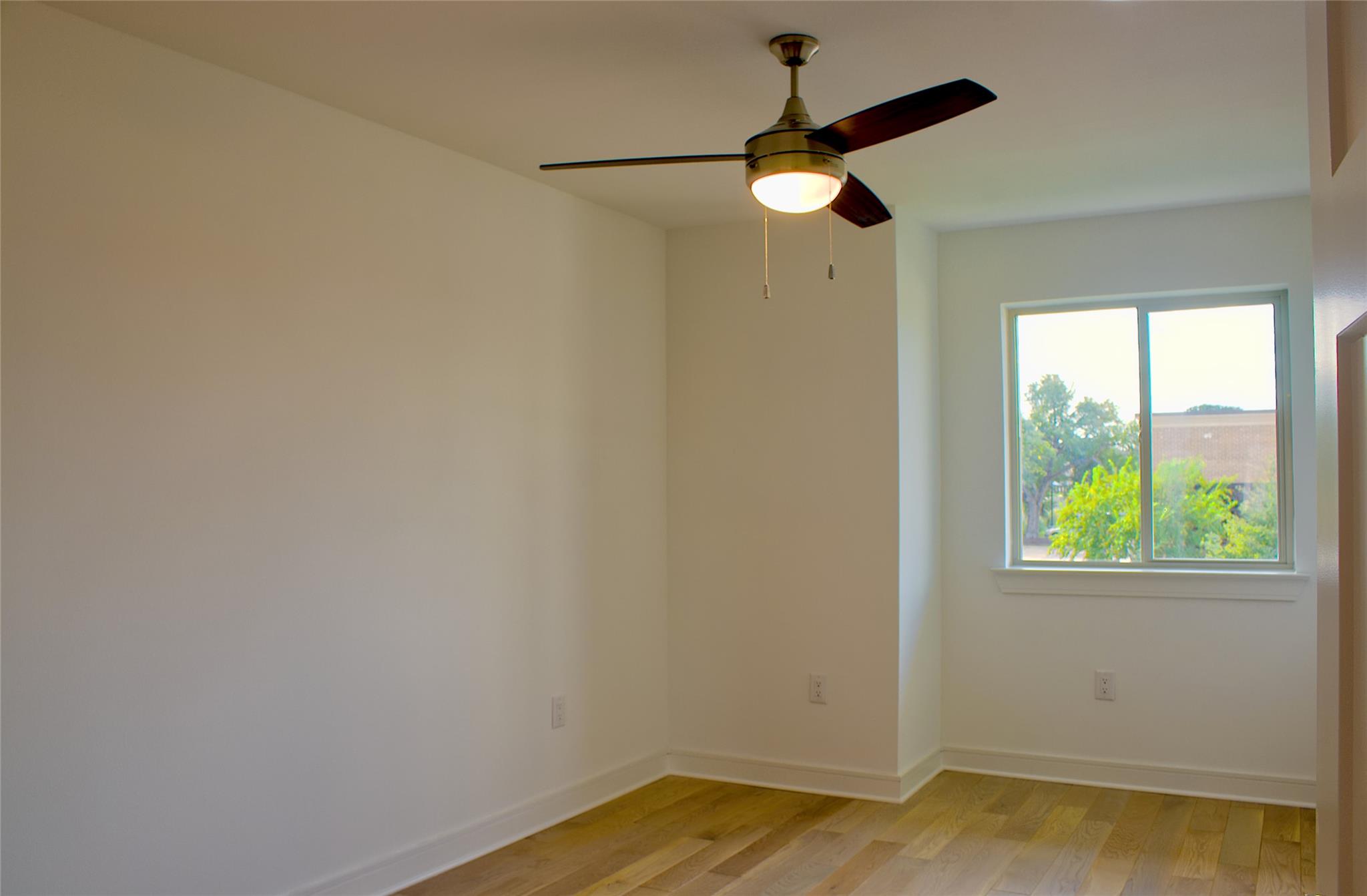 300 Tesla Circle Austin, TX 78681 - Photo 14 of 39 Room with light wood-finish flooring, a ceiling fan with integrated lighting, a white window frame, and white baseboards