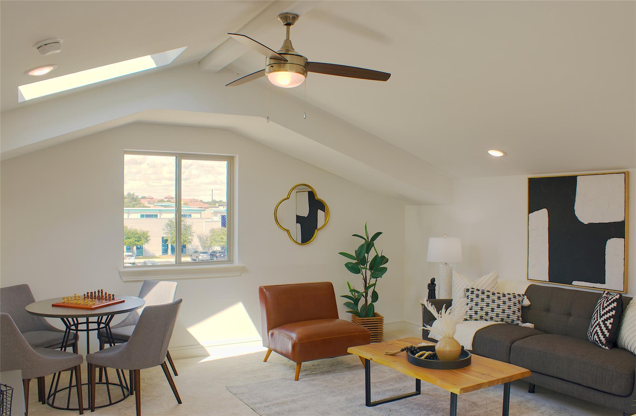 300 Tesla Circle Austin, TX 78681 - Photo 17 of 39 Vaulted ceiling living area featuring a skylight, a ceiling fan with integrated lighting, recessed lighting, and a window