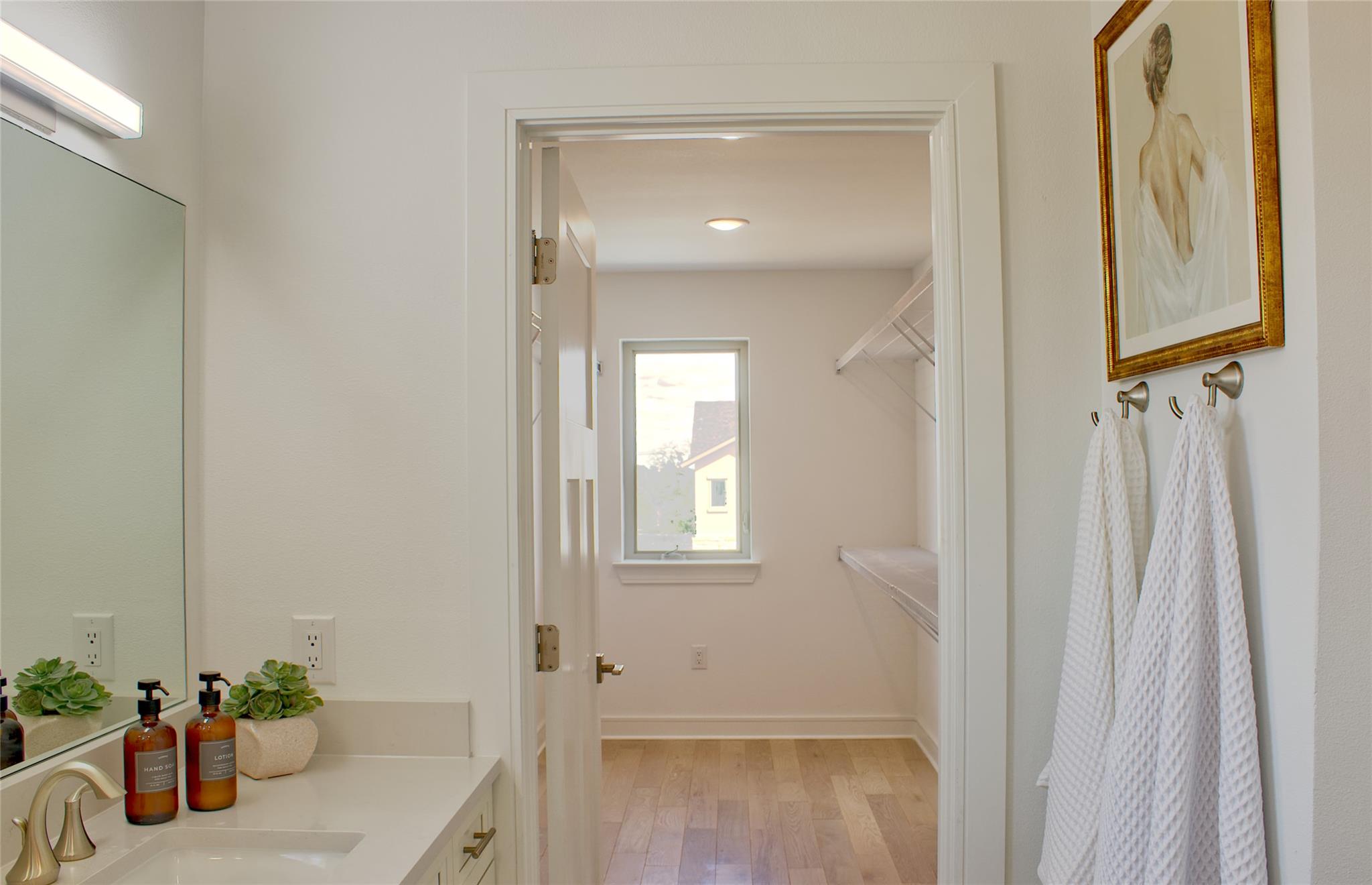300 Tesla Circle Austin, TX 78681 - Photo 26 of 39 Bathroom vanity featuring a single sink, light-colored countertop, and a large wall mirror