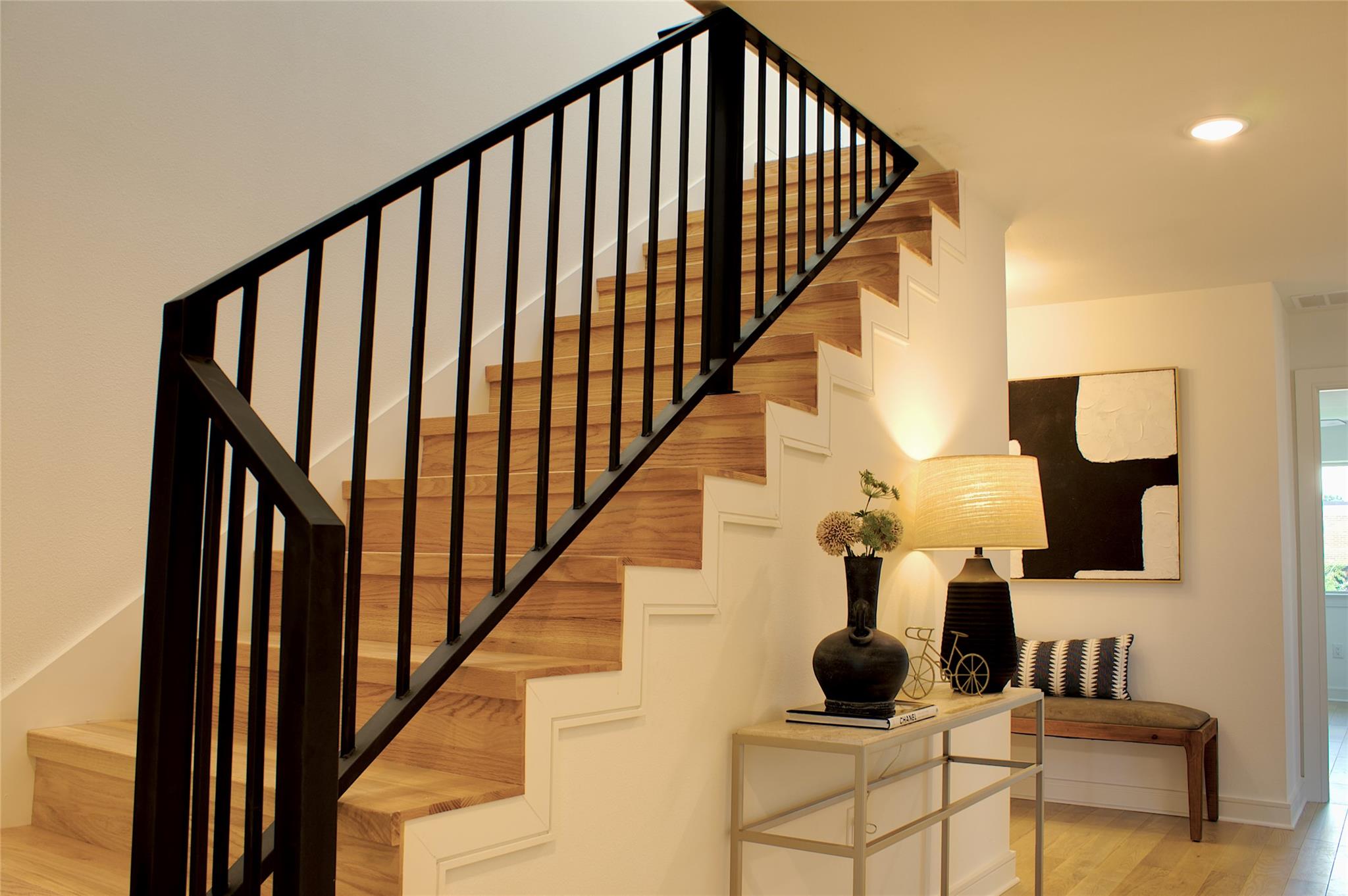 300 Tesla Circle Austin, TX 78681 - Photo 28 of 39 Staircase featuring wood-finish treads and risers, a modern black metal balustrade, and a white stringer