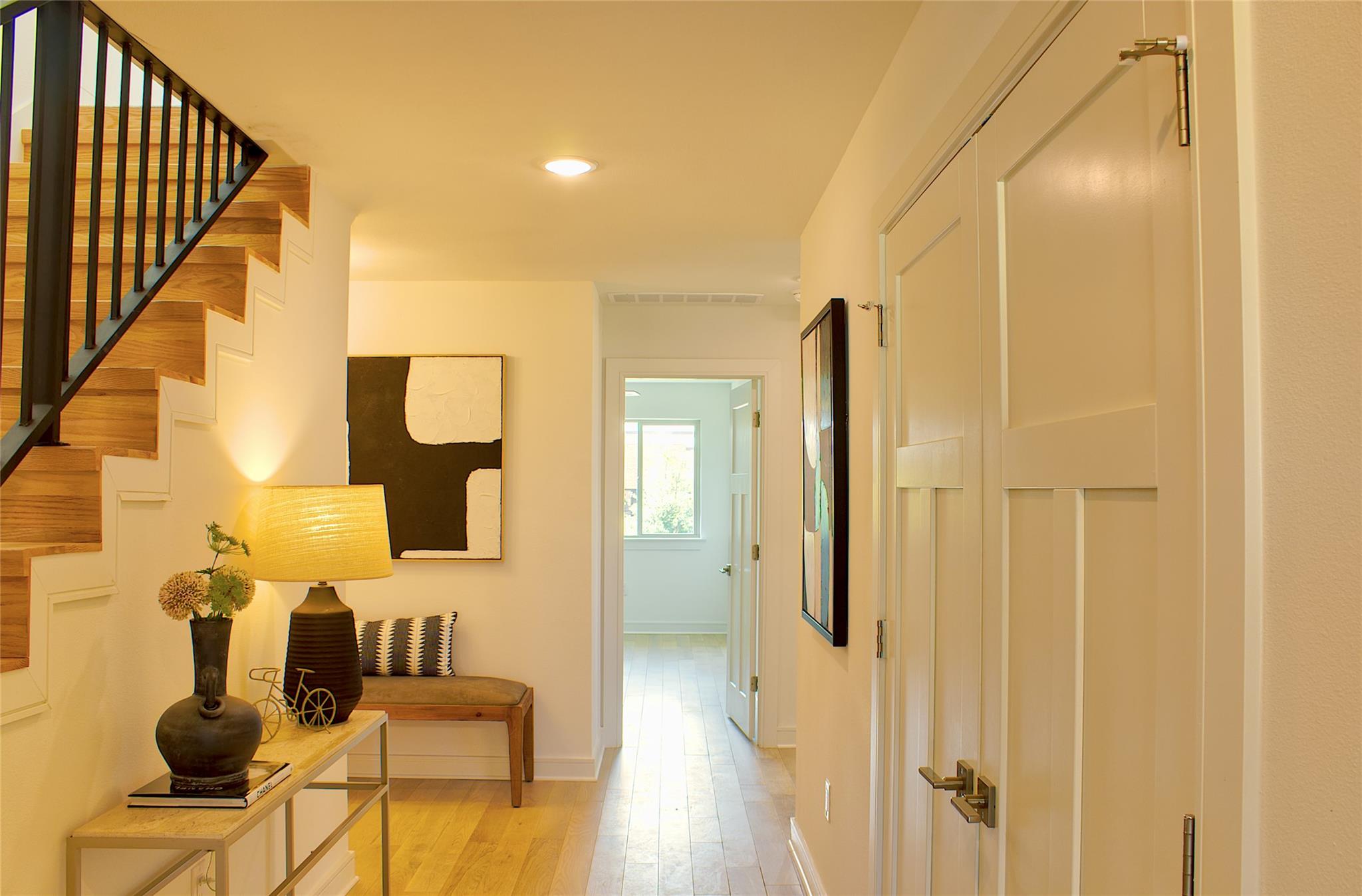 300 Tesla Circle Austin, TX 78681 - Photo 29 of 39 Entryway featuring wood-finish flooring, a contemporary staircase with black metal railings, recessed ceiling lighting, and a white paneled closet door with brushed brass hardware