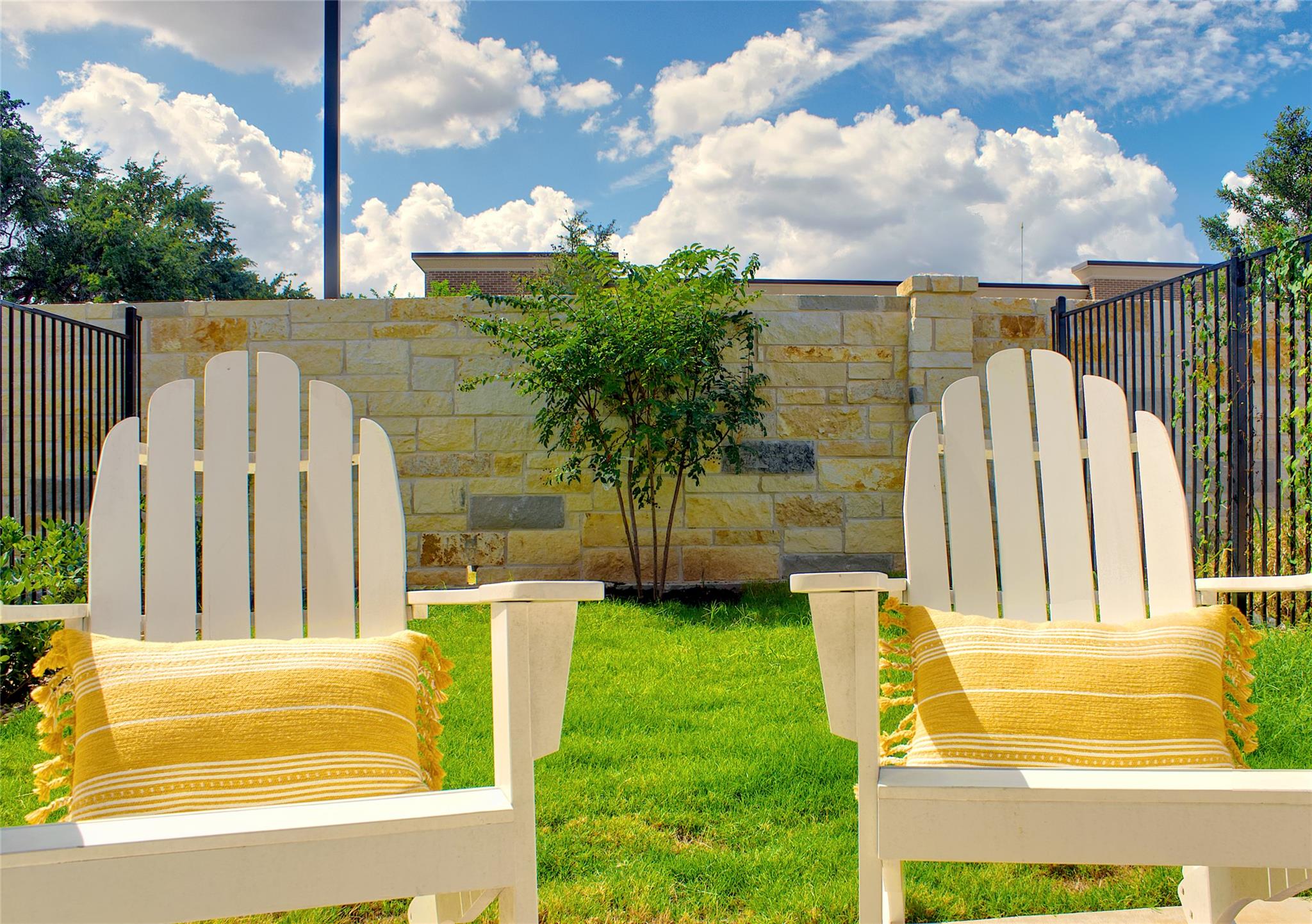 300 Tesla Circle Austin, TX 78681 - Photo 36 of 39 Manicured lawn area with a stone privacy wall and black metal fencing