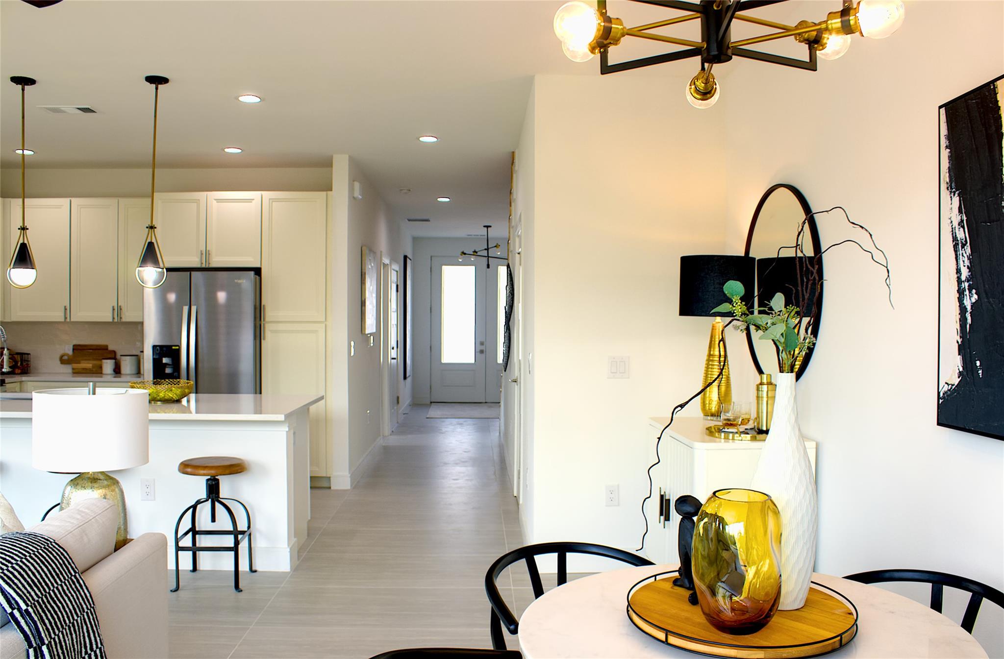 300 Tesla Circle Austin, TX 78681 - Photo 4 of 39 Open-concept living space featuring light-toned flooring, a modern chandelier with exposed bulbs, and a kitchen island with pendant lighting