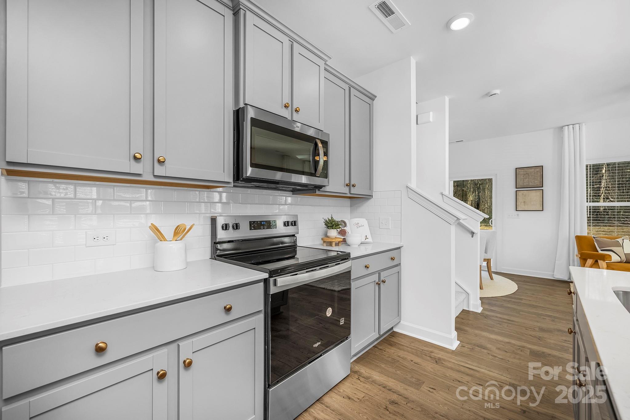 2125 Tom Sadler Road, Unit 7159 Charlotte, NC 28214 - Photo 3 of 26 a kitchen with stainless steel appliances granite countertop white cabinets a stove top oven a sink and dishwasher