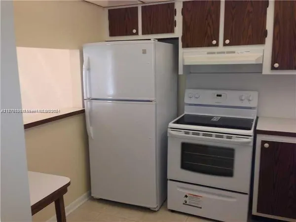 a white refrigerator freezer and a stove sitting inside of a kitchen