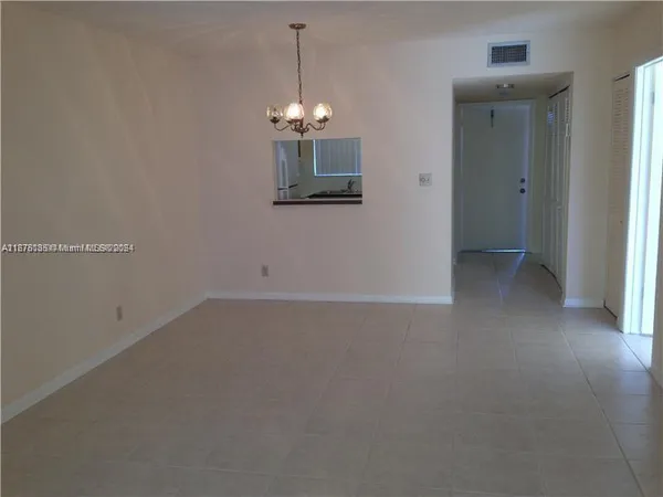 a view of a room with a ceiling fan and window