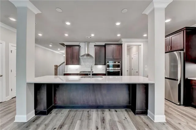 a kitchen with stainless steel appliances a sink refrigerator and cabinets