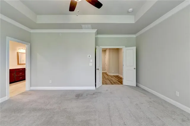 an empty room with a ceiling fan and windows