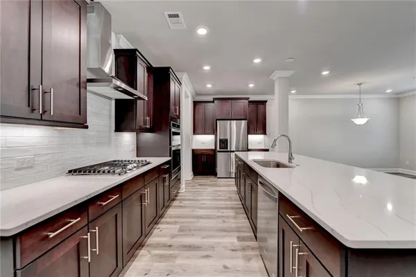 a large kitchen with stainless steel appliances granite countertop a sink a stove and a refrigerator
